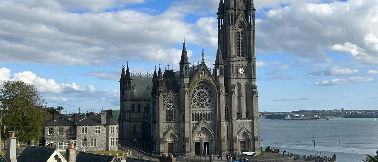 A line of colorful houses with an impressive Gothic cathedral behind them