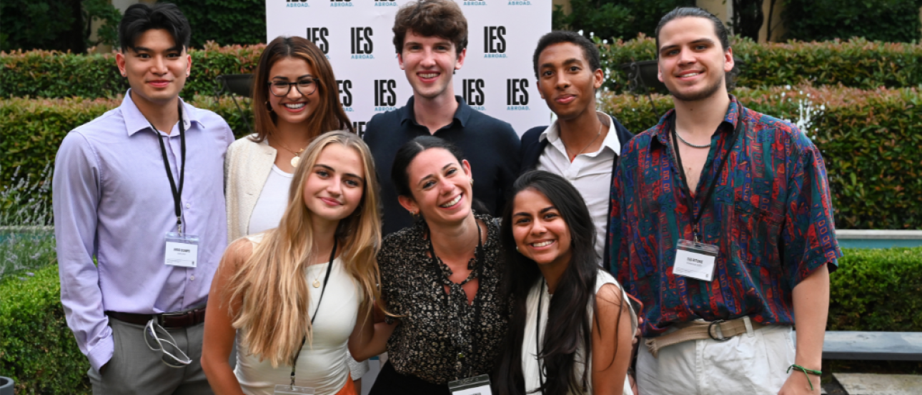 Group of students standing outside in front of an IES Abroad logo backdrop