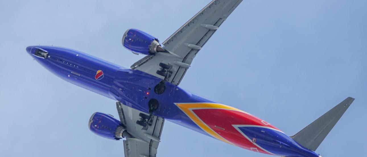 An airplane flying overhead in a blue sky