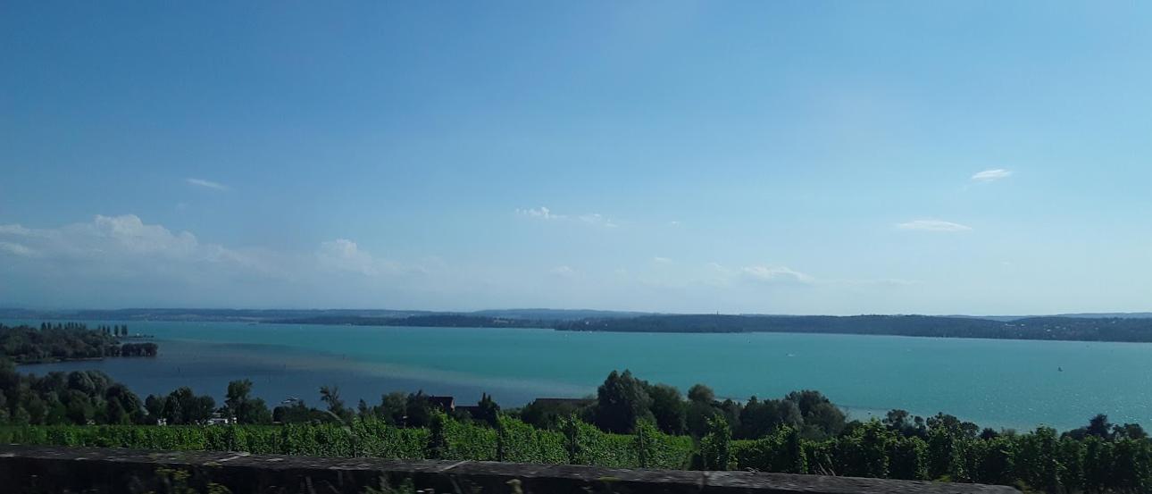 The aquamarine waters of Lake Constance are visible over a hill