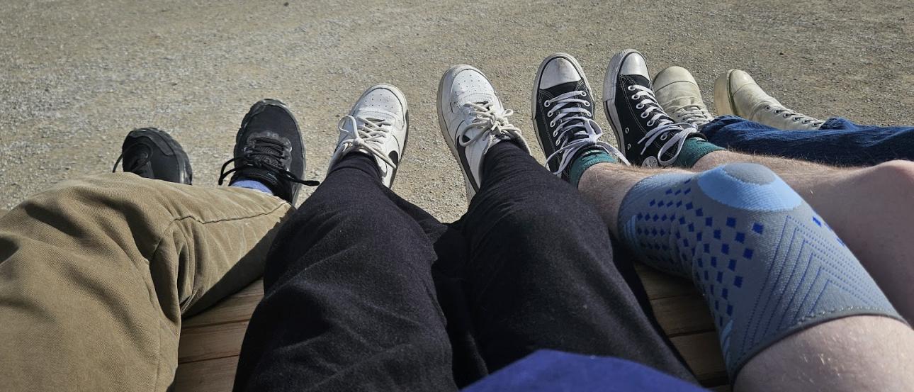 A picture of four friends' pairs of shoes against a large bench in Salzburg, Austria.