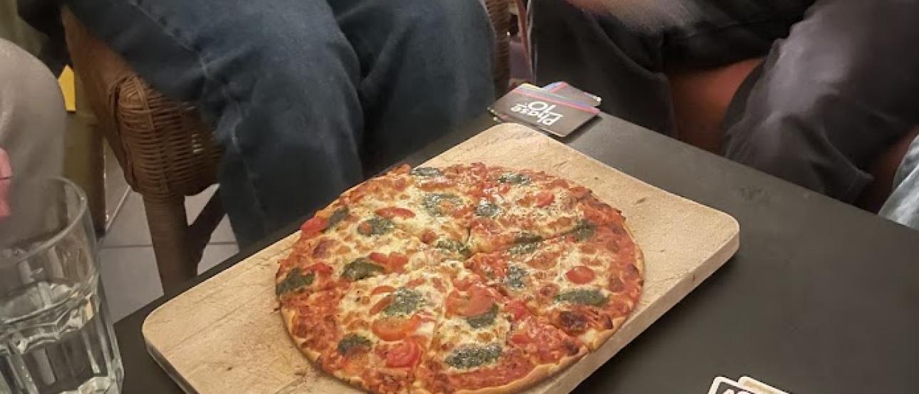 People playing Phase 10 and eating pizza