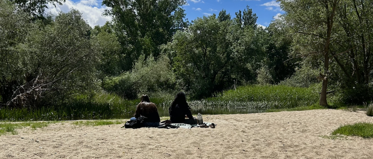 Friends sitting at the river on a sunny day in Salamanca