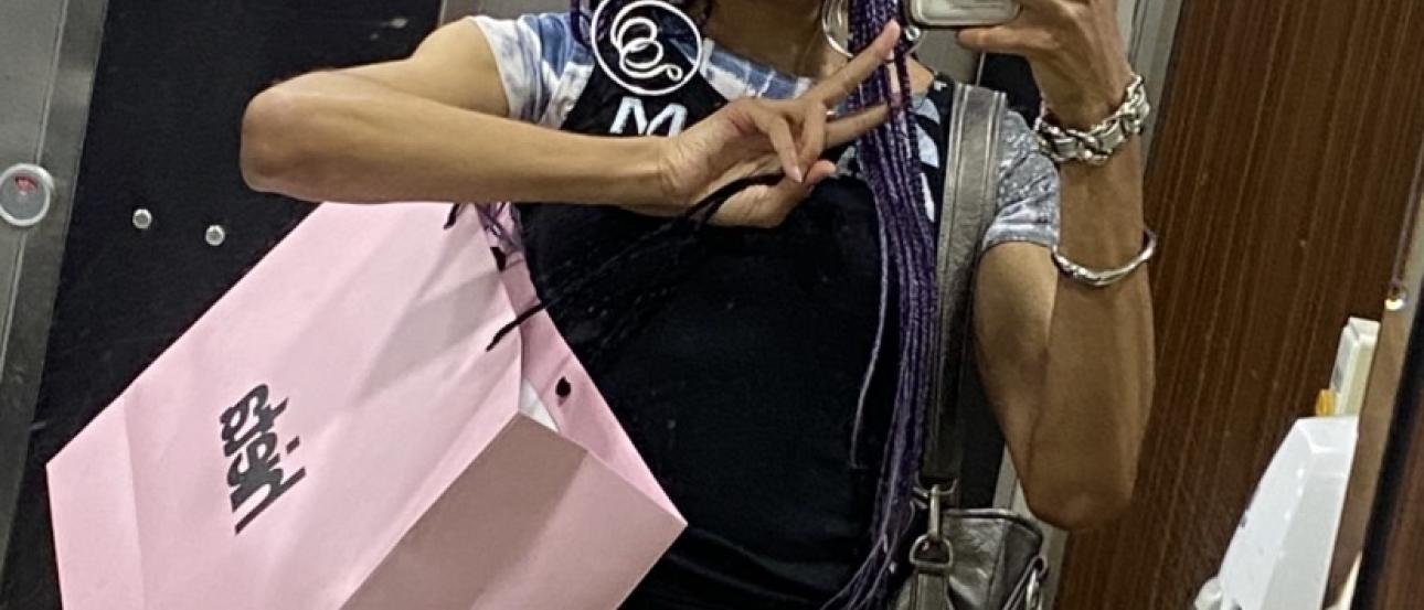 A mirror selfie of me holding a pink shopping bag that says "hieta" while holding up a peace sign.