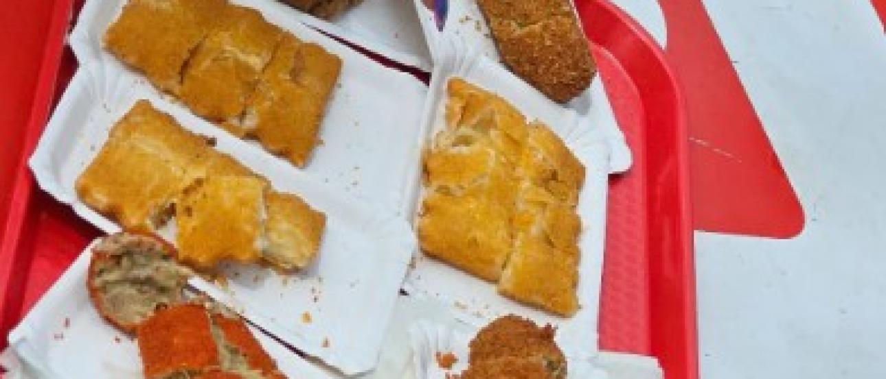 A sampling display of a saucy beef or cheese filling that is shaped into a breaded and fried ball. 