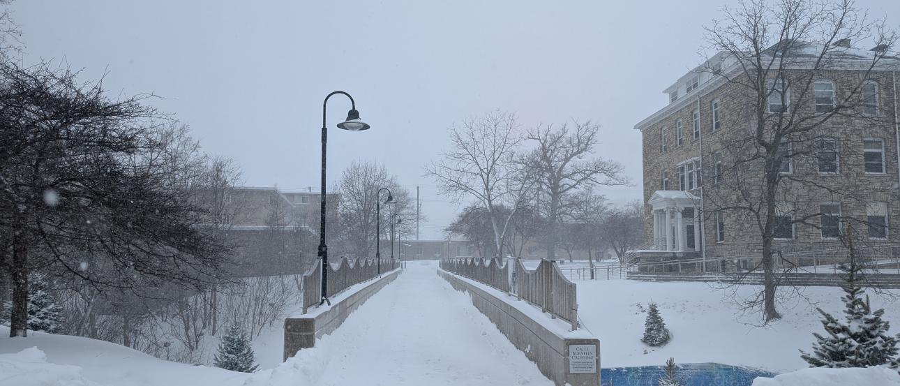 A bridge at Lawrence University in Appleton in dim light, covered in snow.