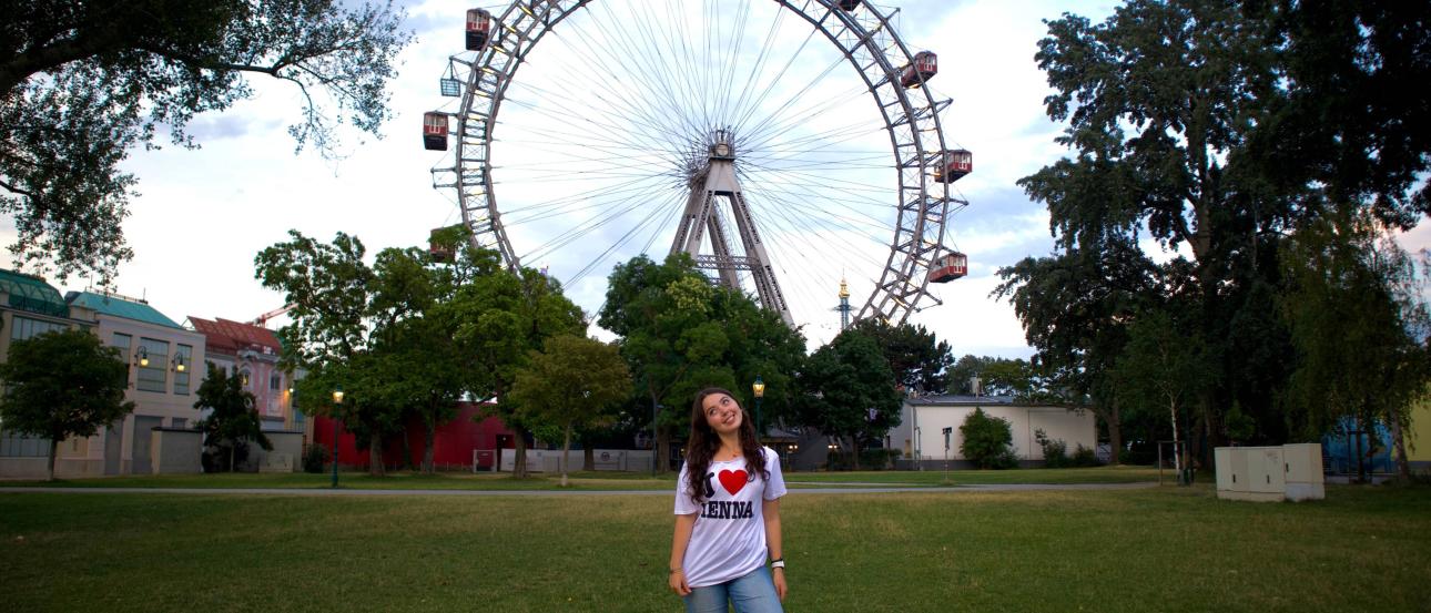 A girl in front of the Prater Ferris wheel