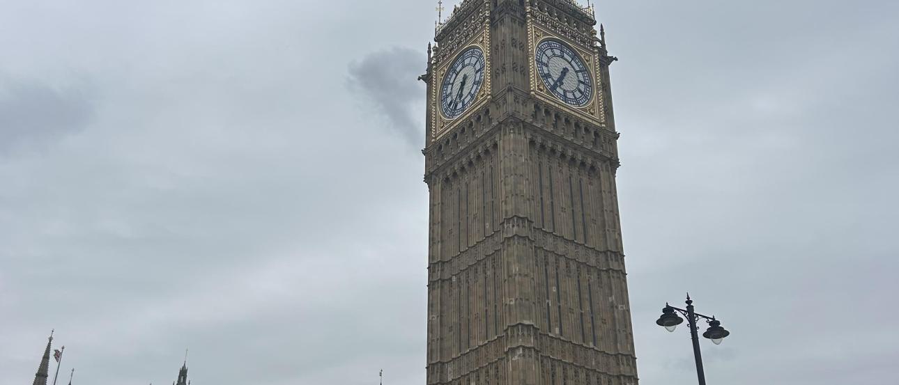 The bell tower at the Houses of Parliament set against gray skies.