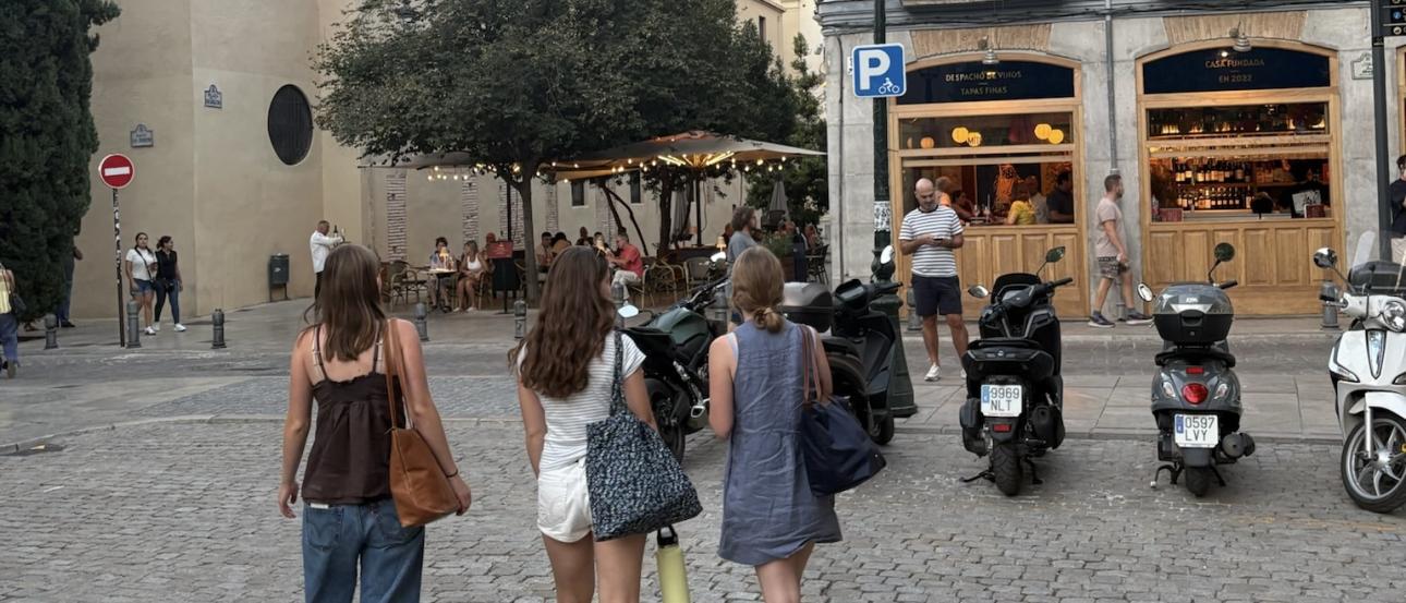 3 students walking through a plaza