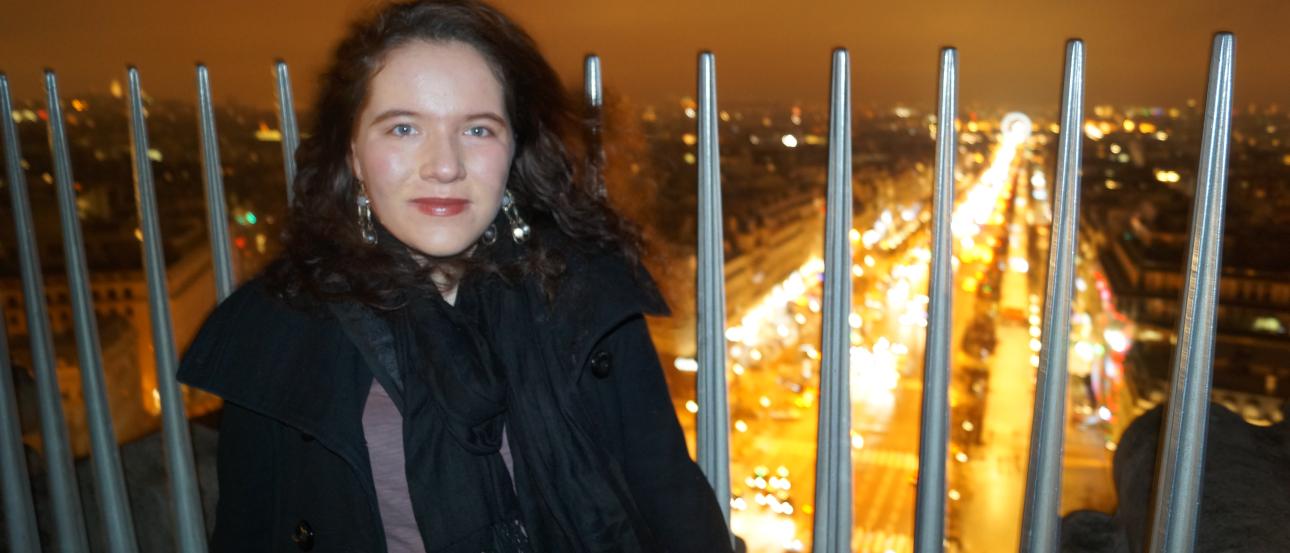 Three people standing in front of ancient ruins with arches, sunny day. This alt text was added with Al; accuracy may vary.