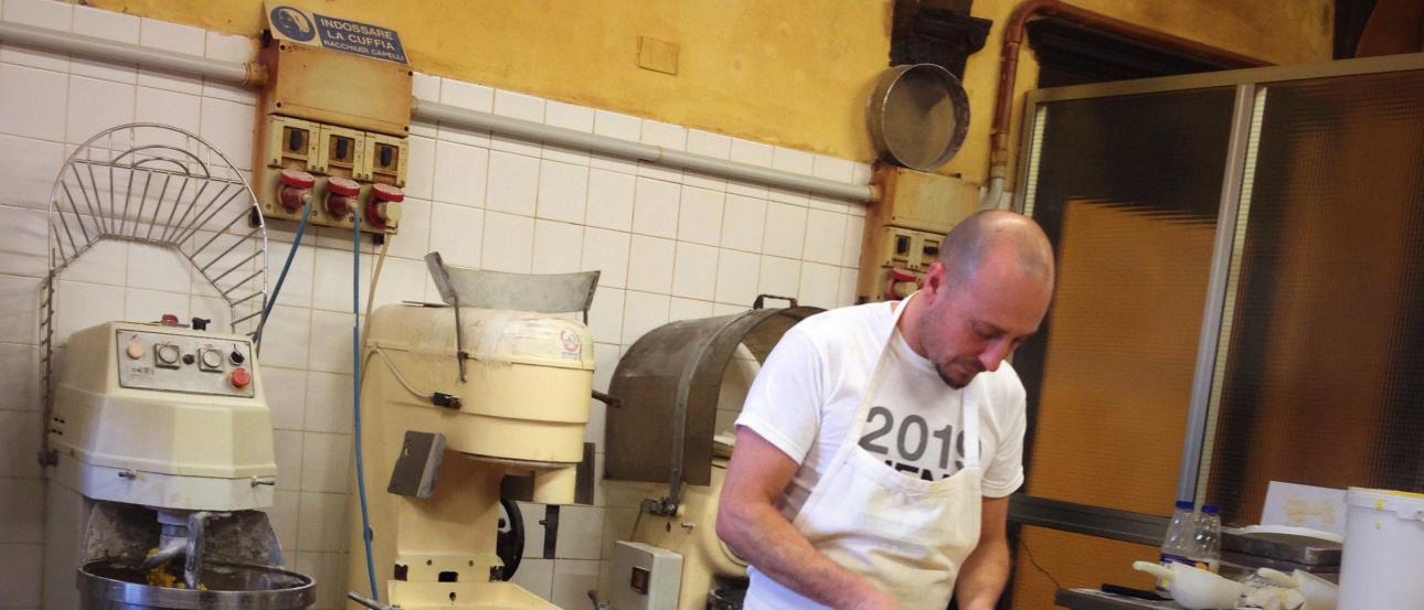Crowded subway platform with passengers and train, exit sign above. This alt text was added with Al; accuracy may vary.