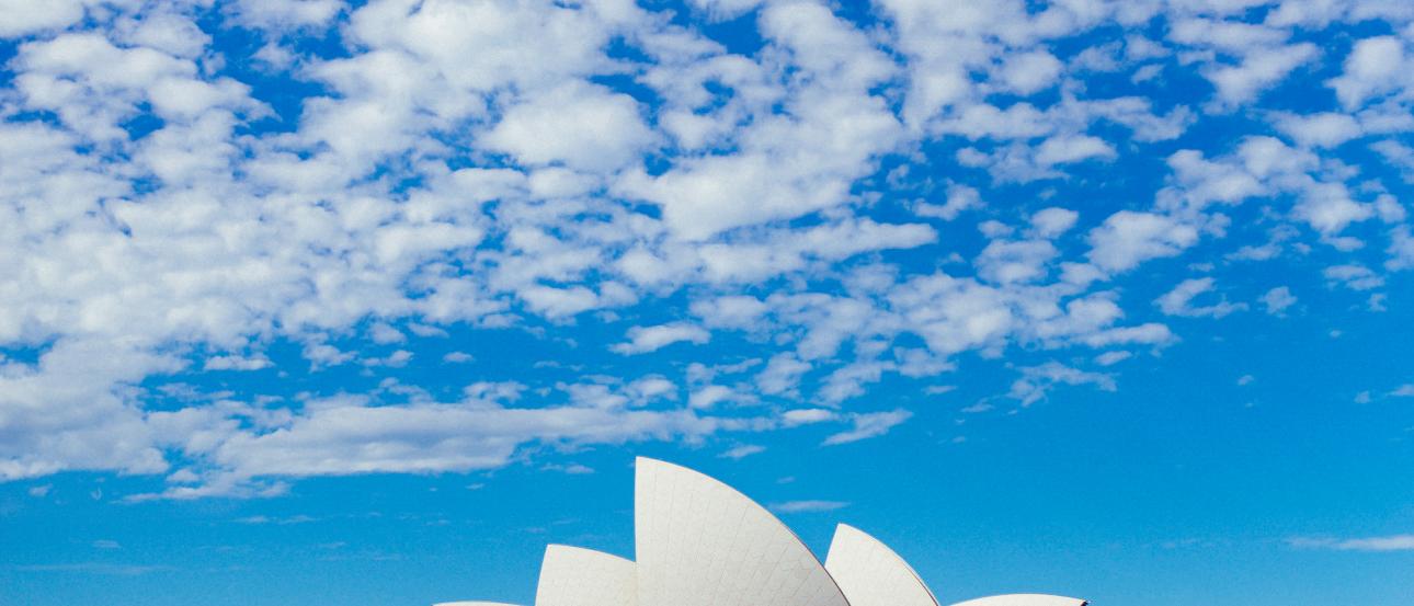 Scattered postcards on a red and orange bedspread. This alt text was added with Al; accuracy may vary.