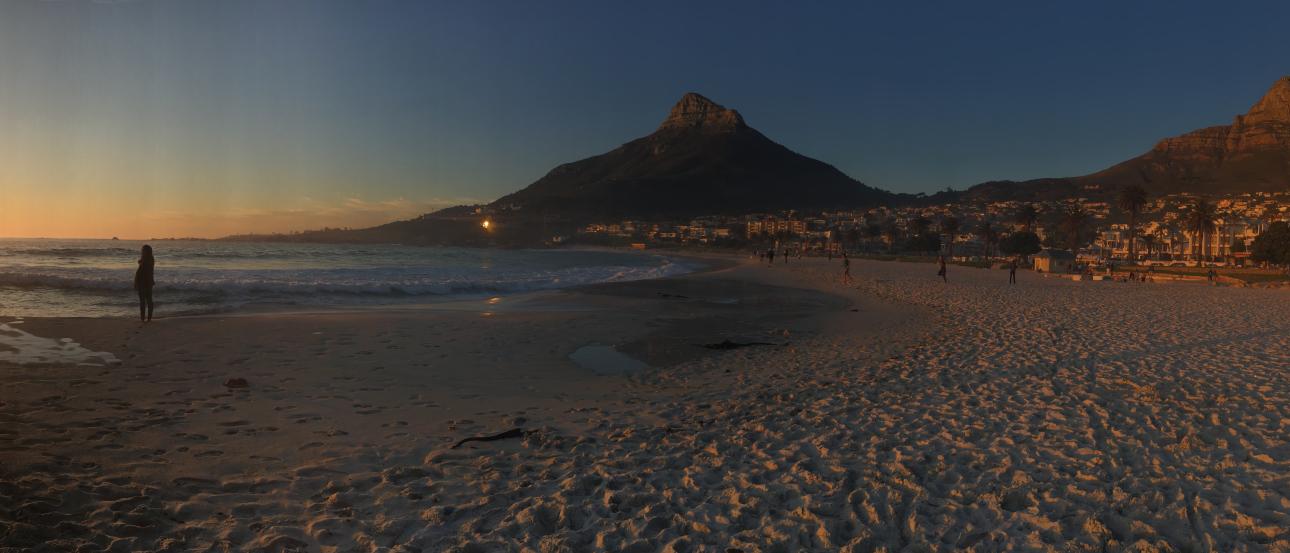 Group posing at sunset with Uluru in the background. This alt text was added with Al; accuracy may vary.
