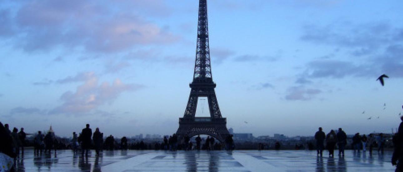 Crowd gathered in a park under sunlit trees.

Performer in traditional costume under trees, crowd watching.

Eiffel Tower against a blue sky, silhouetted by evening light. This alt text was added with Al; accuracy may vary.