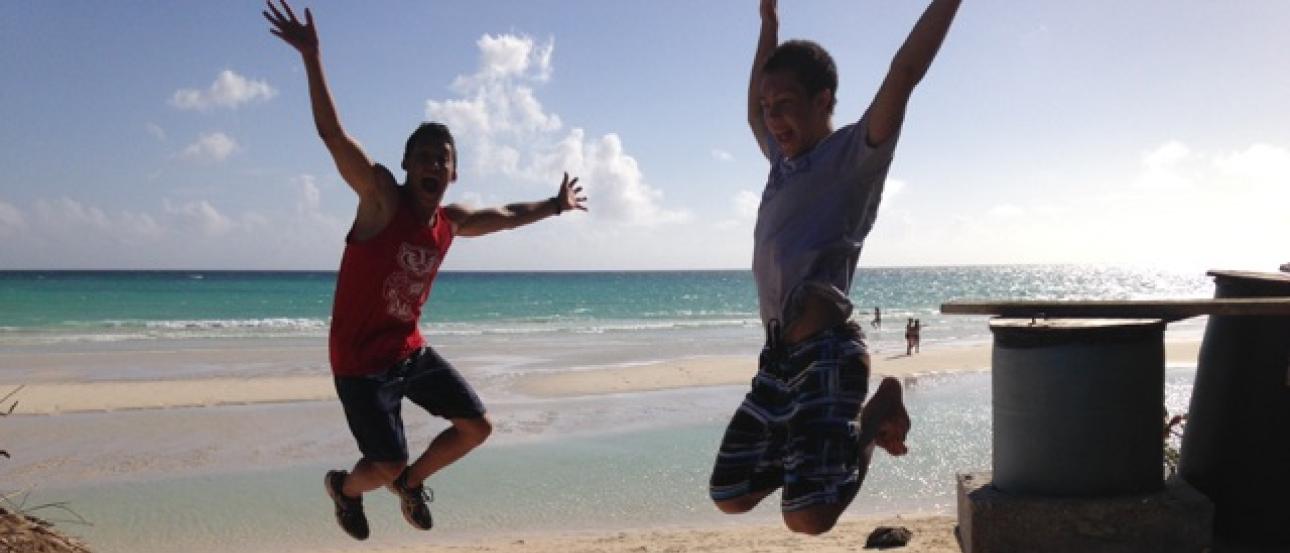 Two people jumping on a sunny beach