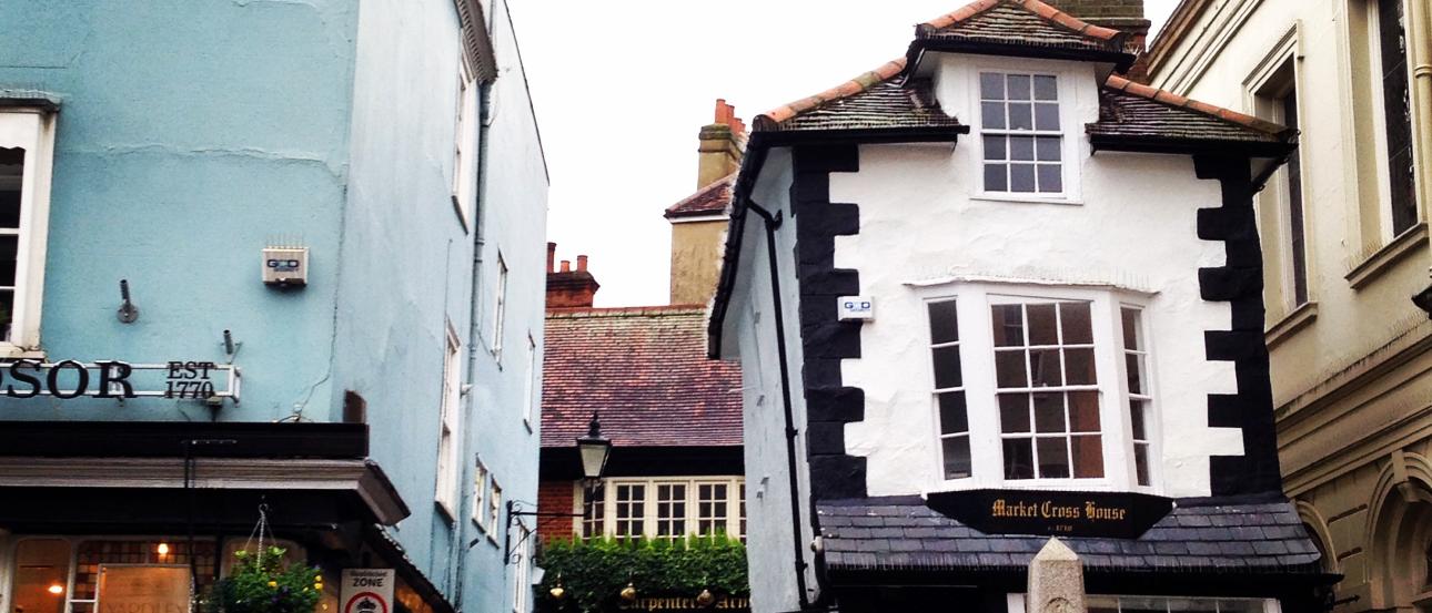 Charming street with colorful buildings and a historic pub in Windsor. This alt text was added with Al; accuracy may vary.