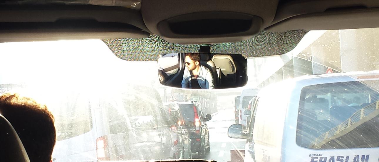 Child on sunny hillside, blue sky.  
Inside view of car, looking at city traffic. This alt text was added with Al; accuracy may vary.