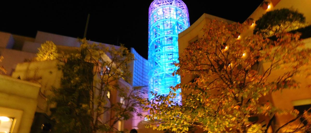 1. Basketball court with players and spectators under warm lights.
2. Scoreboard shows tied score, 36-36, with 2.27 remaining.
3. Group of people walking down a narrow, bright corridor.
4. Vibrantly lit cylindrical tower in a courtyard at night. This alt text was added with Al; accuracy may vary.