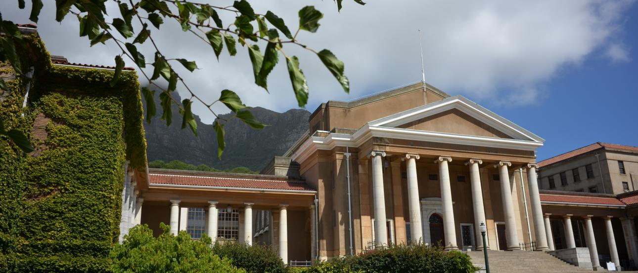 Historic town rooftops with red tiles under a hazy sky. This alt text was added with Al; accuracy may vary.