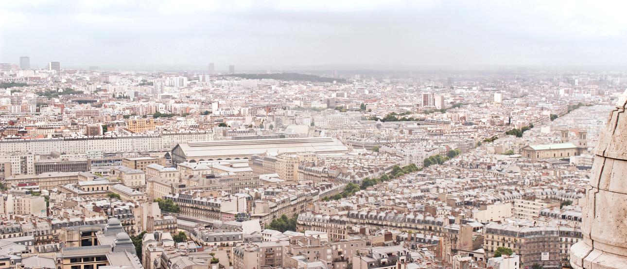 Travel essentials on a world map, including a camera, compass, and currency.

Cityscape of Paris with dense buildings under a cloudy sky. This alt text was added with Al; accuracy may vary.