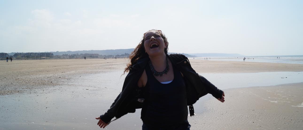 1. Pink bicycle by a canal with historic buildings.
2. Rooftop view of a European city with mixed architecture.
3. Person joyfully walking on a sandy beach, arms outstretched. This alt text was added with Al; accuracy may vary.