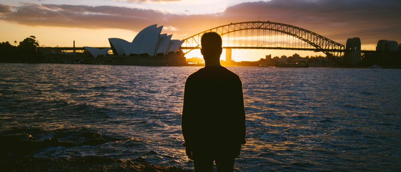 Group of children smiling with an adult in a sunny outdoor setting. This alt text was added with Al; accuracy may vary.