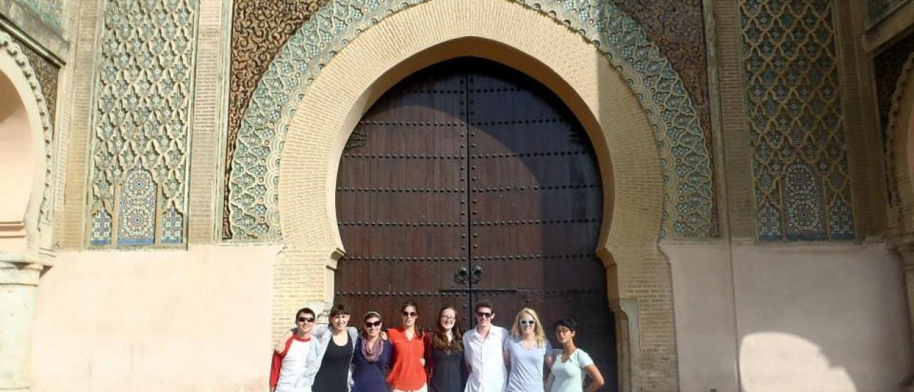 1. Tall stone tower with intricate architecture under a cloudy sky.
2. Christ figure in front of illuminated blue wall inside a church.
3. Group of people standing in front of a large, ornate arched gateway. This alt text was added with Al; accuracy may vary.