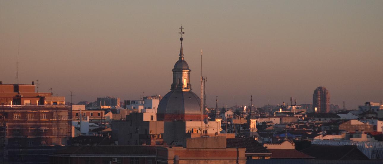 City skyline at sunset with a domed building in the center. This alt text was added with Al; accuracy may vary.