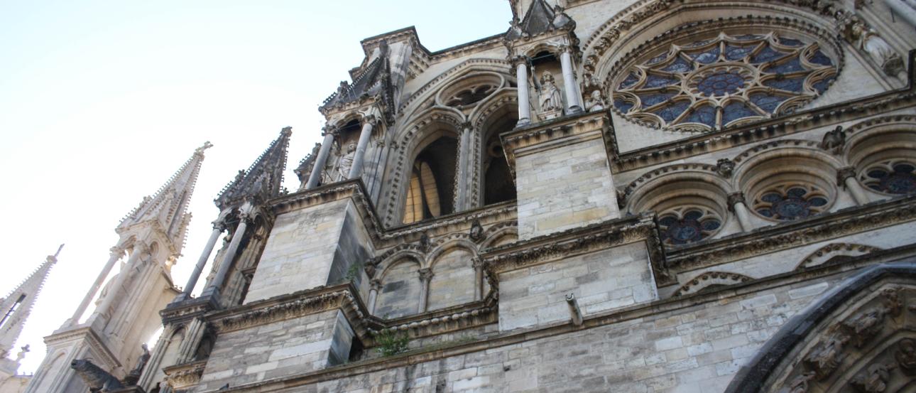Gothic cathedral interiors with arches, stained glass windows, and a statue holding a child. This alt text was added with Al; accuracy may vary.