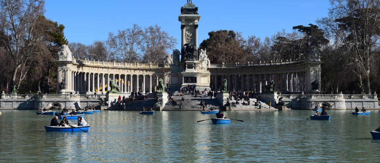 Man standing on a pipe over water, holding another's hand for balance. This alt text was added with Al; accuracy may vary.