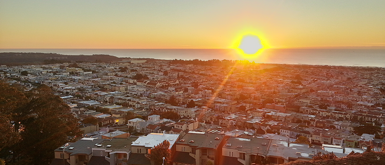 Sunset over a cityscape with a glowing horizon and scattered buildings. This alt text was added with Al; accuracy may vary.