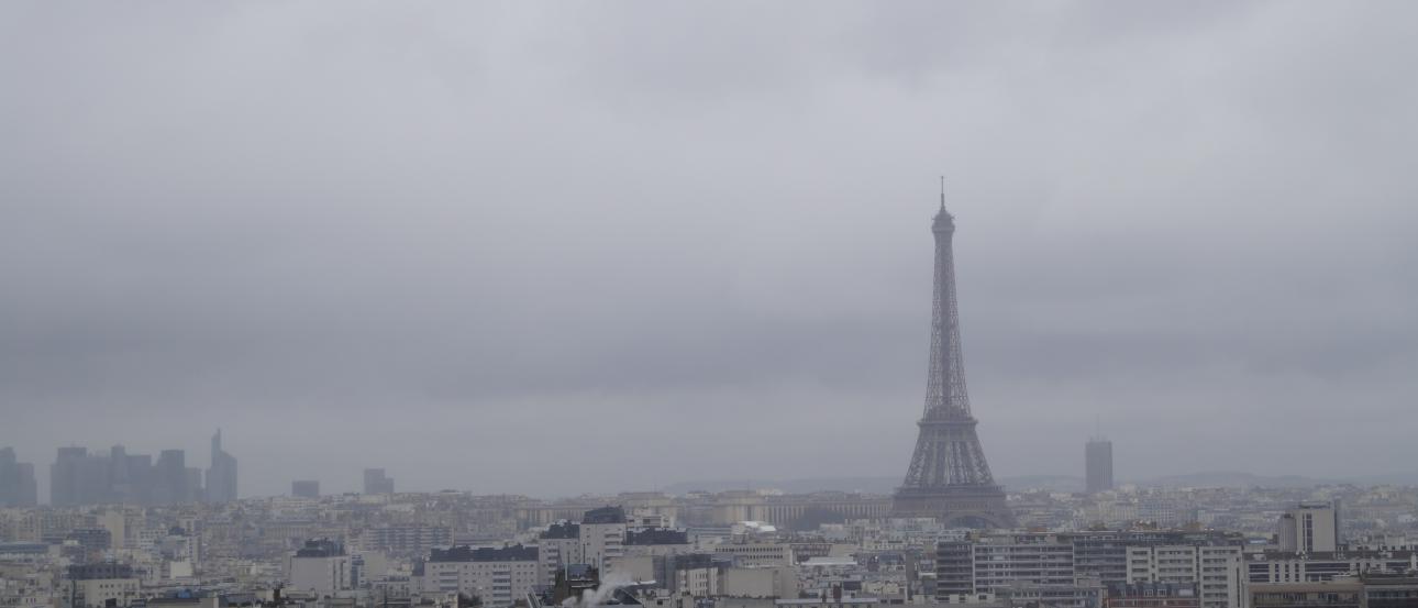 Cloudy Paris skyline with Eiffel Tower in the distance. This alt text was added with Al; accuracy may vary.