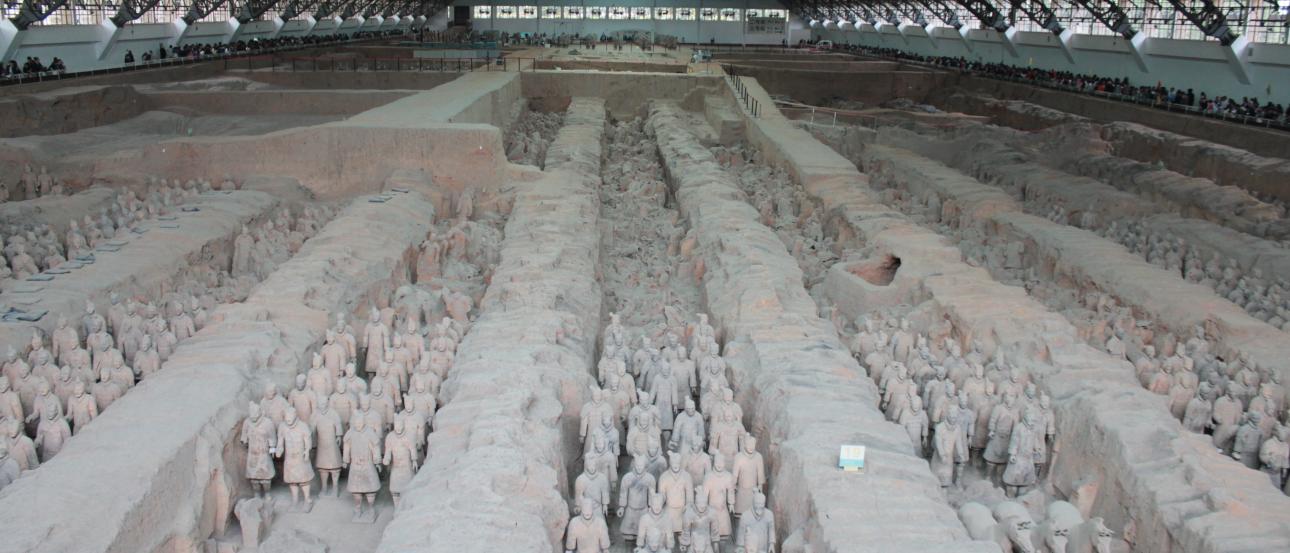 Terracotta Army statues in a large, covered excavation site. This alt text was added with Al; accuracy may vary.