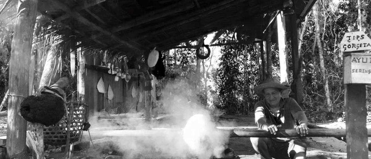 Sandy path through trees with wooden fence and sign. This alt text was added with Al; accuracy may vary.