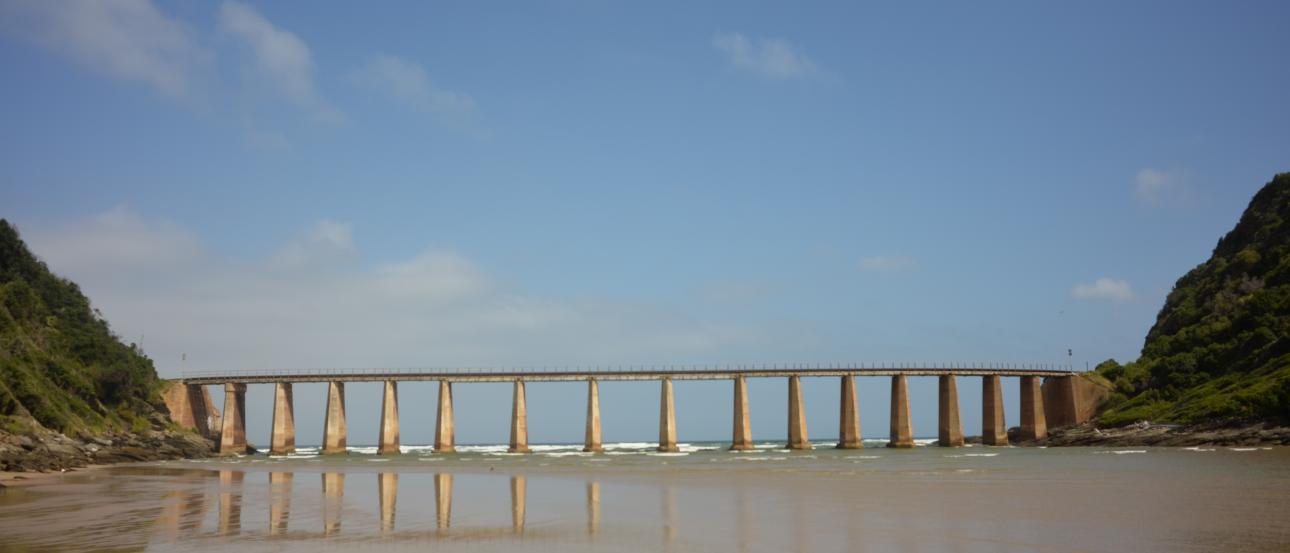 Skyline of Paris with Eiffel Tower under cloudy skies.

Sandy beach with a long viaduct and hills in the distance. This alt text was added with Al; accuracy may vary.
