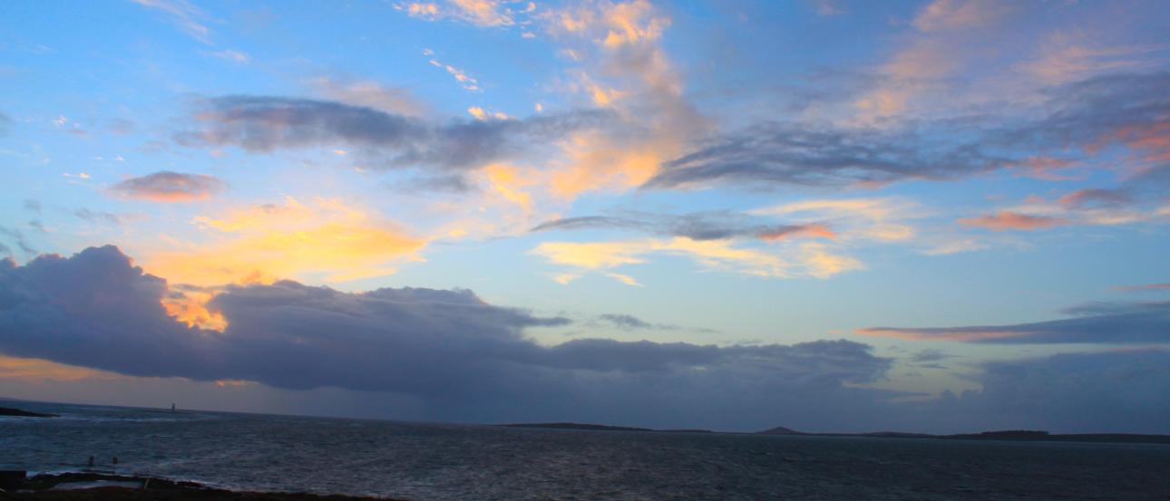 Rolling hills with stone wall under cloudy sky. This alt text was added with Al; accuracy may vary.