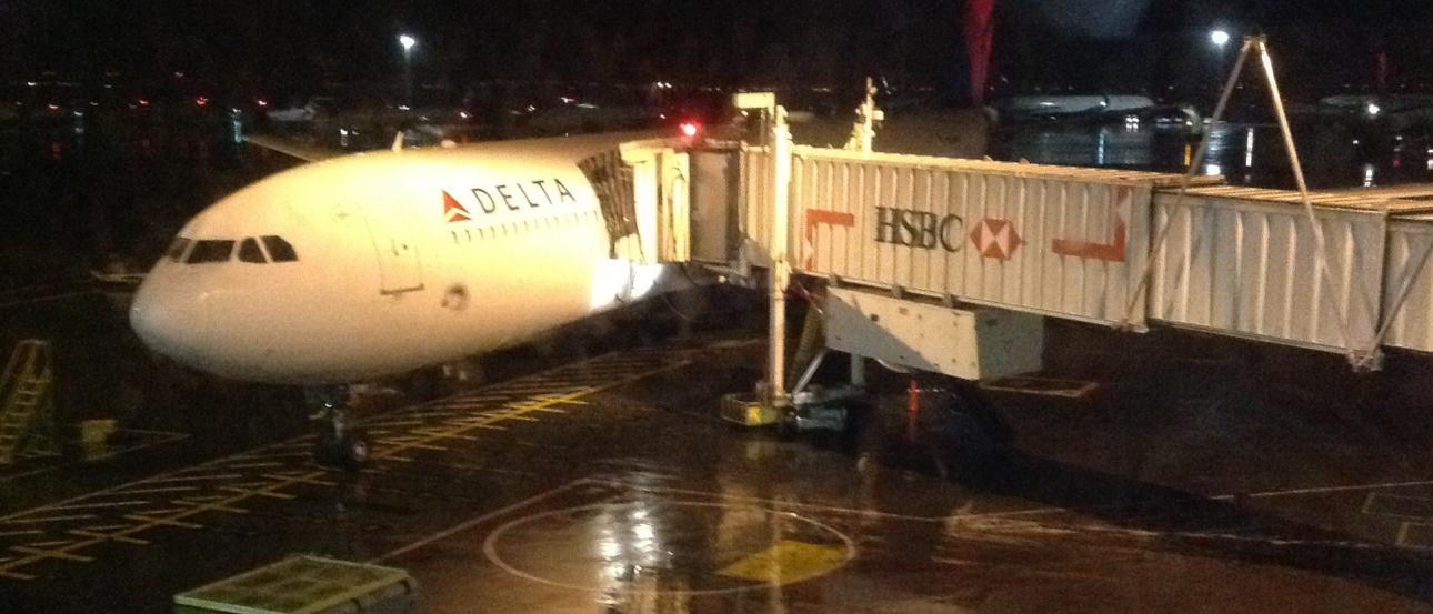 Black suitcase with orange hiking boots in front. This alt text was added with Al; accuracy may vary.