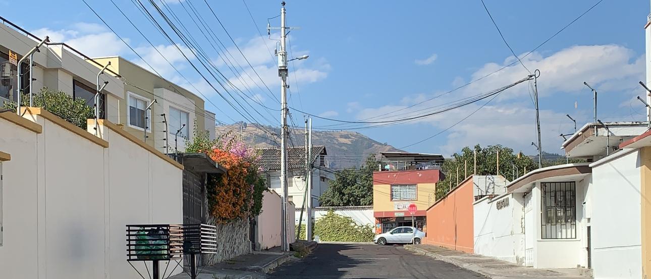 Residential street with colorful buildings and mountains in the background