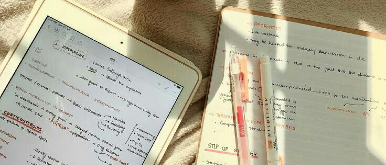 Cup, book and Ipad on a white sheet
