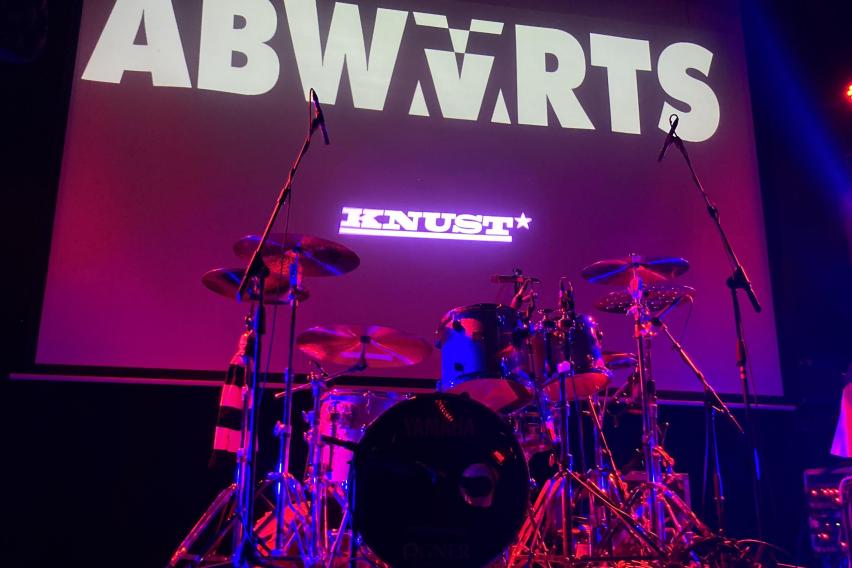 My front row view of the stage for the Abwärts concert, with the band name and a drum set visible.