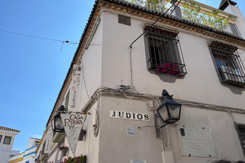 White sign that says Judios on a white building in the Jewish quarter of Cordoba
