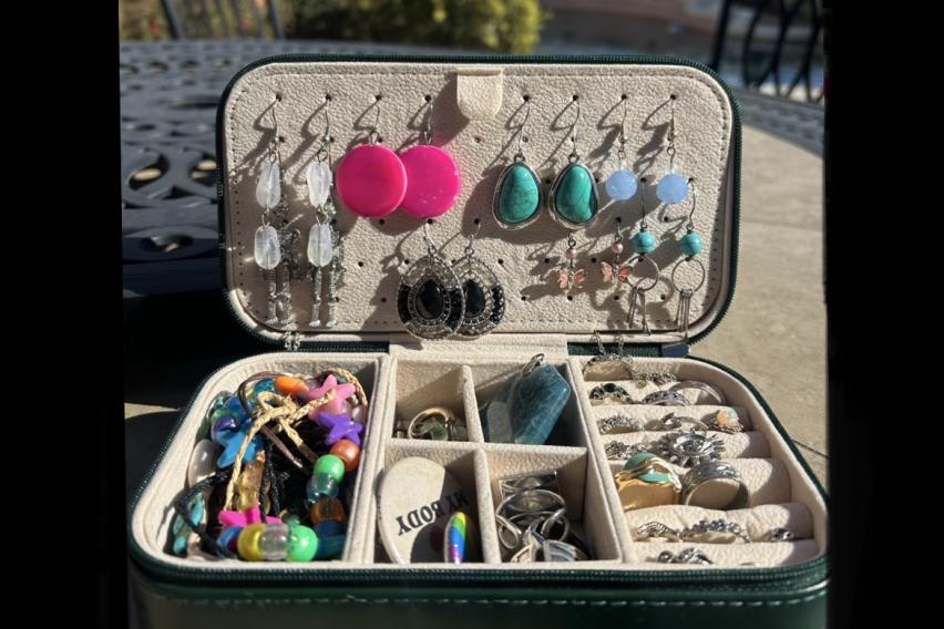 A travel jewelry case that contains earrings, bracelets, necklaces, and rings. 