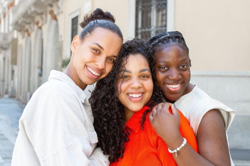 Three students laughing and posing on a bright sunny day in Milan