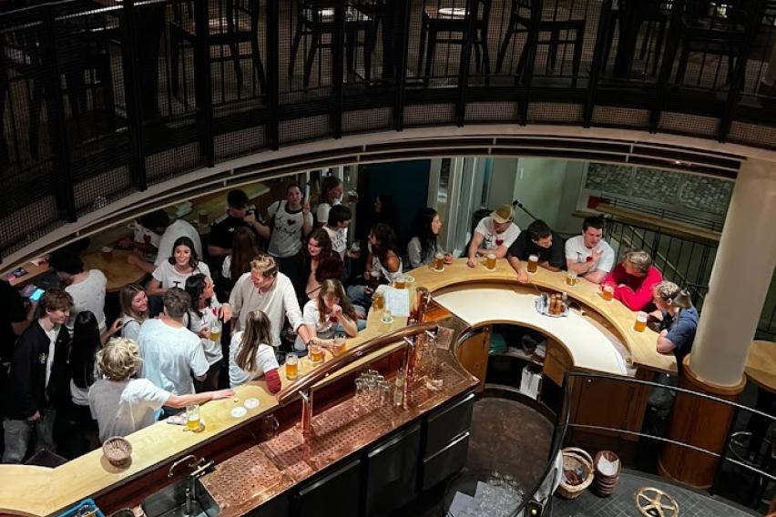 Aerial shot of a group of people in a bar, chatting and drinking.