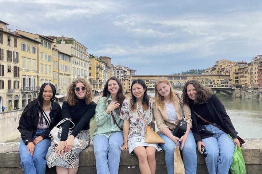  Group of 6 female friends on a bridge in Florence, Italy. With a river in the background.
