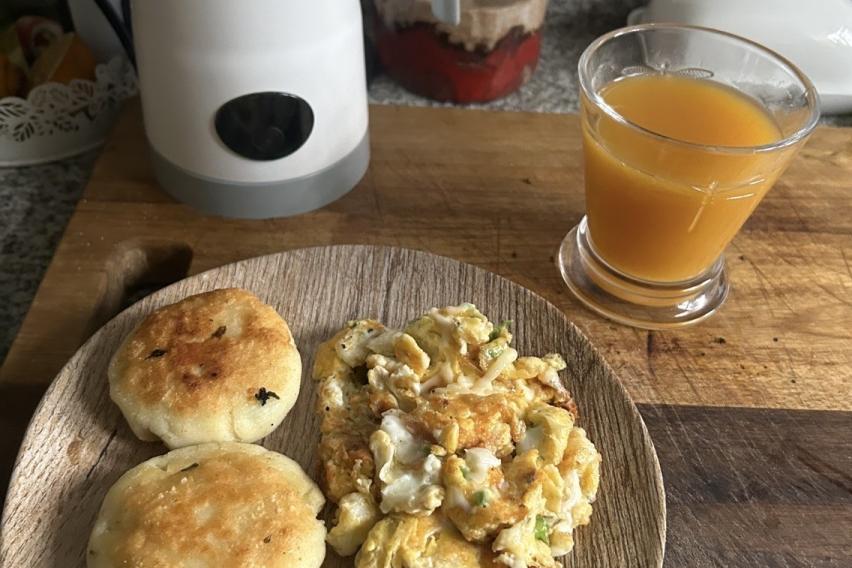 Tortillas de maiz con queso and scrambled eggs accompanied by peach juice
