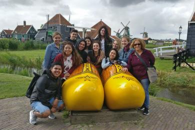 a group of students sitting in giant clogs in Zaanse Schans