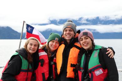 students on a boat in Patagonia, Chile with a Chilean flag