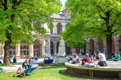 a green area of University of Vienna with students sitting outside