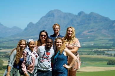 a group of students pose for a photo in front of mountains in Cape Town